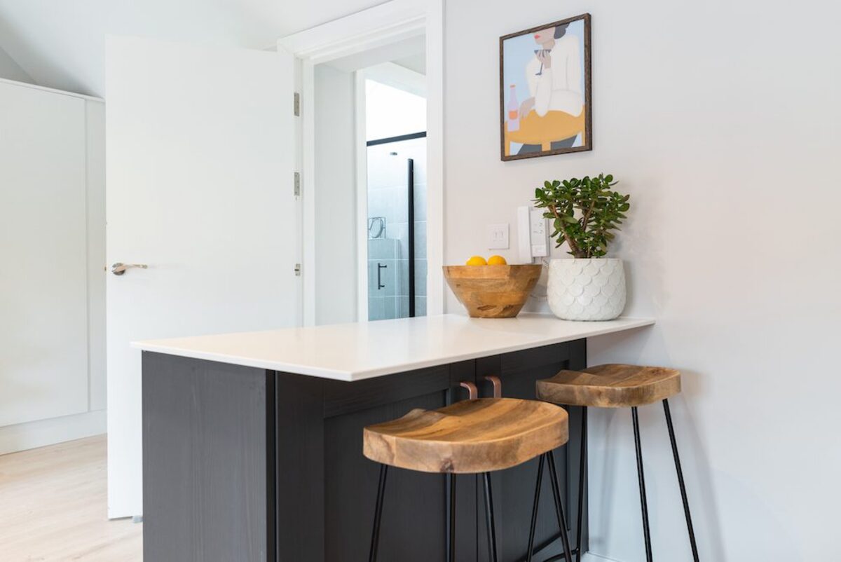 Kitchen breakfast bar with wooden stools jade plant and artwork in EirStay corporate accommodation Camden Street Dublin 2