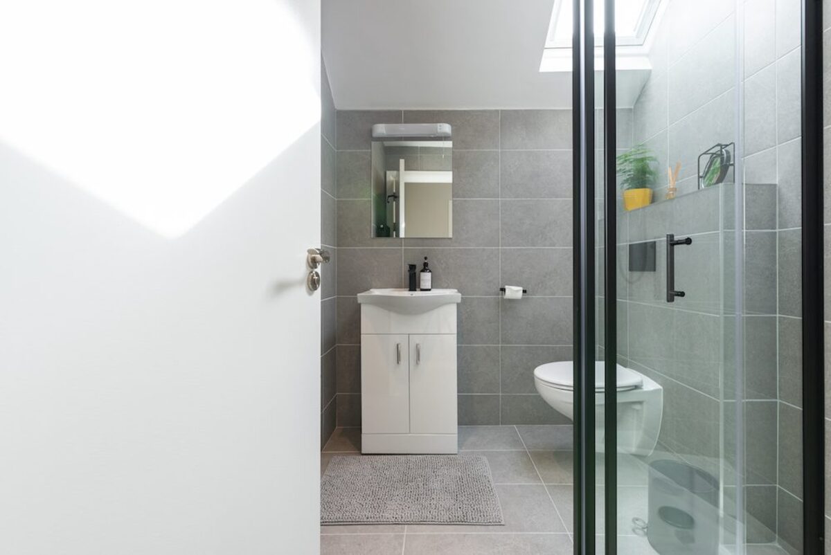 Modern bathroom with grey tiles skylight vanity and walk-in shower in EirStay corporate short stay apartment Camden Street Dublin 2