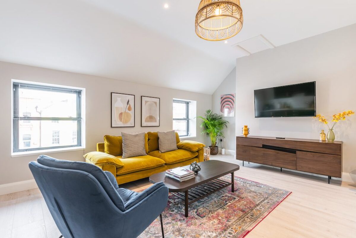 Smart TV and walnut sideboard with blue accent chair in EirStay corporate short stay apartment Camden Street Dublin 2