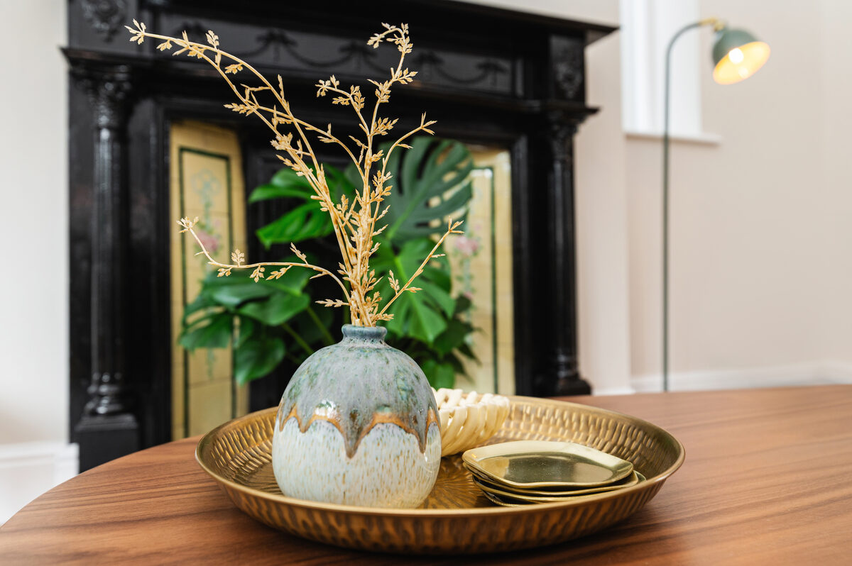 Decorative vase and brass tray on coffee table by period fireplace in EirStay corporate short stay apartment Dublin