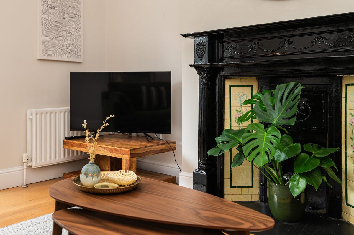 Smart TV and Victorian tiled fireplace detail in EirStay short stay corporate apartment Donnybrook Dublin 4