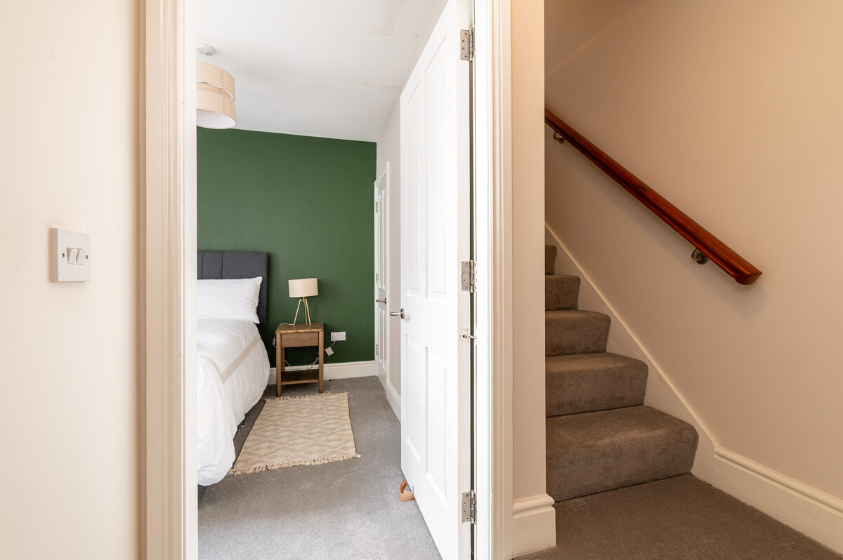 Second bedroom entrance with green accent wall in EirStay corporate short stay apartment Donnybrook Dublin