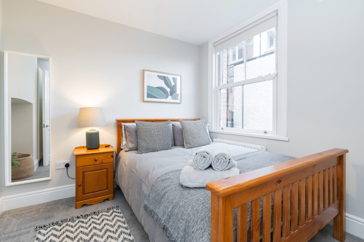 Double bedroom with fresh towels and wooden bed frame in EirStay corporate short stay Morehampton Road Dublin 4