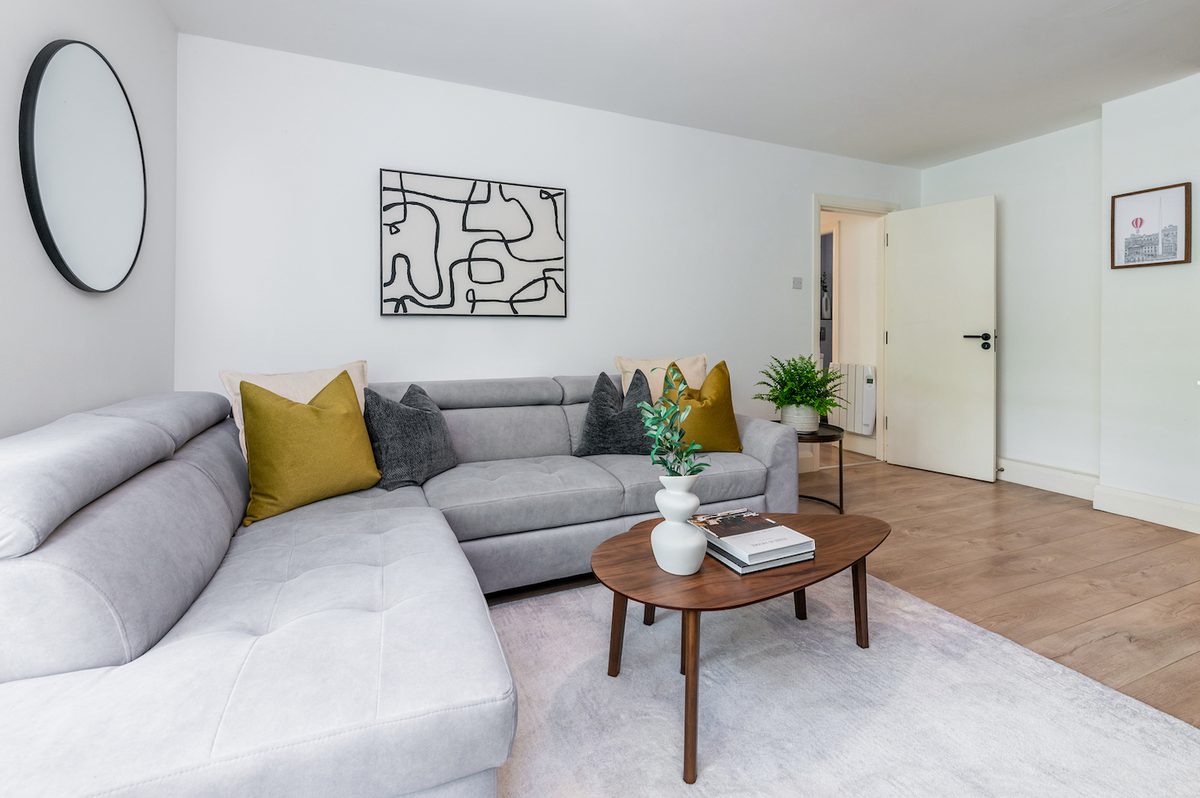 Bright living room with grey corner sofa, wooden coffee table and abstract artwork in EirStay Islandbridge corporate apartment Dublin 8