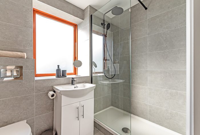 Walk-in shower with rainfall and handheld showerhead glass panel and vanity unit in EirStay corporate accommodation Kilmainham Dublin 8