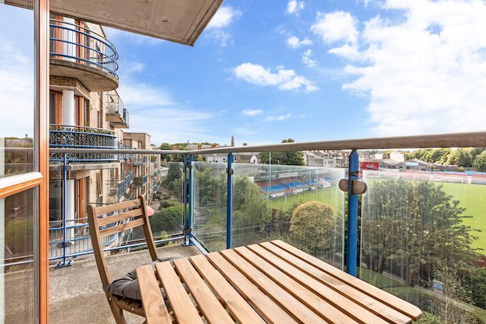 Private balcony with teak table and chair overlooking city and football ground in EirStay corporate short stay Kilmainham Dublin 8