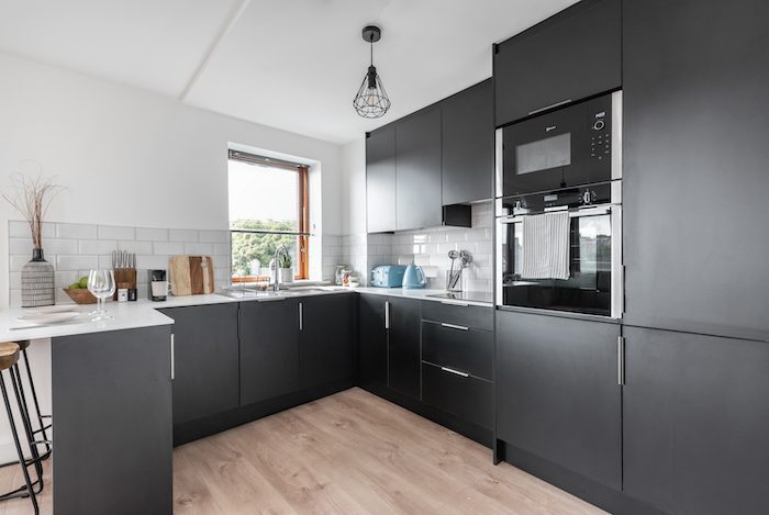 Full kitchen with dark grey cabinetry built-in oven microwave and metro tile splashback in EirStay corporate short stay Kilmainham Dublin 8