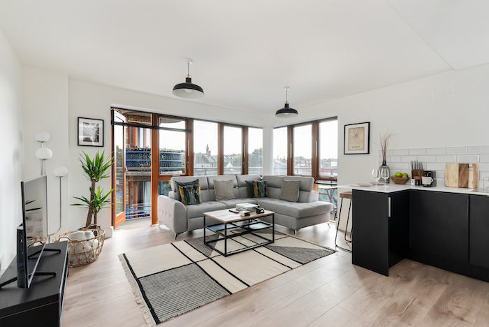 Panoramic living room with floor-to-ceiling windows and open plan kitchen in EirStay serviced apartment Kilmainham Dublin 8